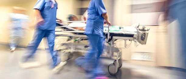 Enfermeiros levando paciente no hospital