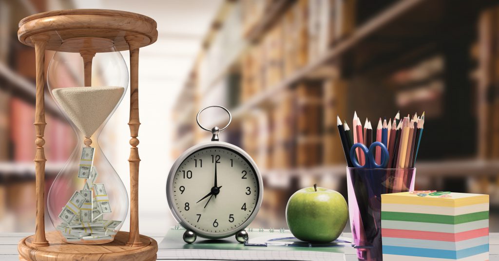 Imagem de uma mesa de estudos com relógio, maçã, lápis e post-its